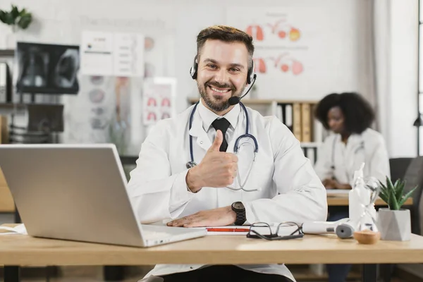 Dokter di headset memiliki panggilan video pada laptop — Stok Foto