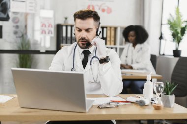 Hasta ile çevrimiçi randevusu olan kulaklıklı bir doktor.