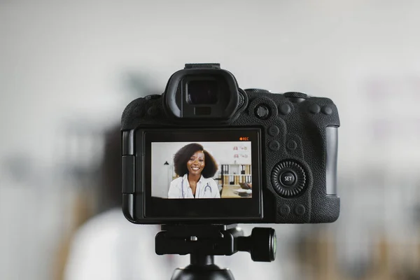 Экран видеокамеры с улыбкой африканской женщины-врача — стоковое фото
