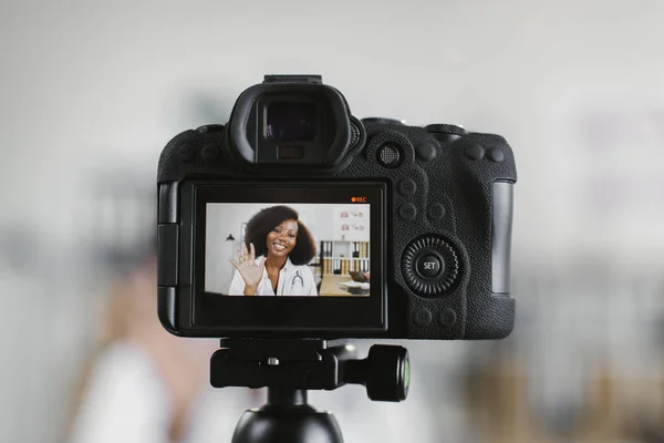 Экран видеокамеры с улыбкой африканской женщины-врача — стоковое фото