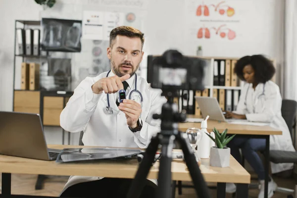 Доктор снимает видео о том, как использовать пульсоксиметр — стоковое фото
