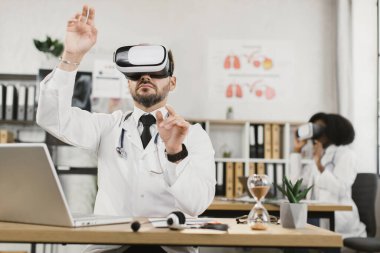 Klinikte çalışırken çeşitli doktorlar VR kulaklık takıyor.