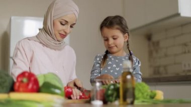 Güzel Müslüman anne ve kızı mutfakta lezzetli yemekler hazırlıyorlar..