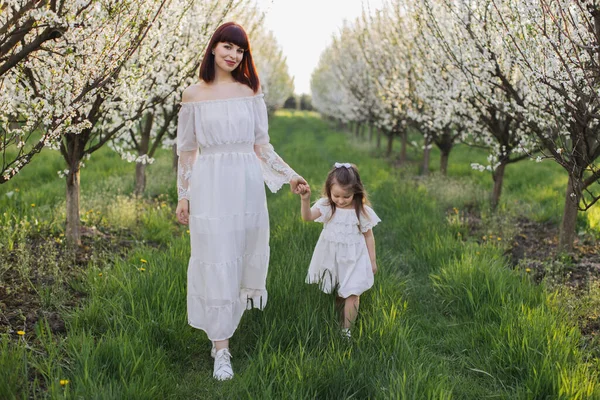 春の庭を歩いている娘の母親 — ストック写真