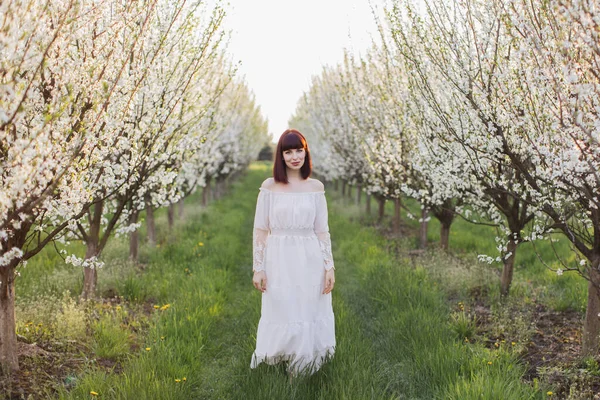 Superbe femme en robe blanche debout au jardin de printemps — Photo