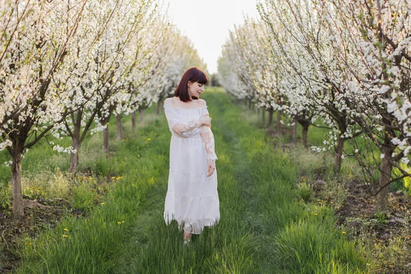 開花リンゴの木の間で官能的にポーズ魅力的な女性 — ストック写真