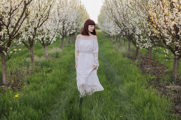 Belle femme caucasienne marchant au jardin de printemps en fleurs — Photo
