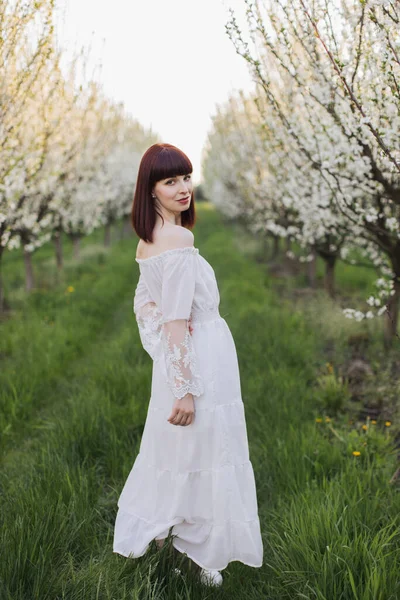 아름다운 흰옷을 입은 멋진 여인 이 샘 정원에서 있다 — 스톡 사진