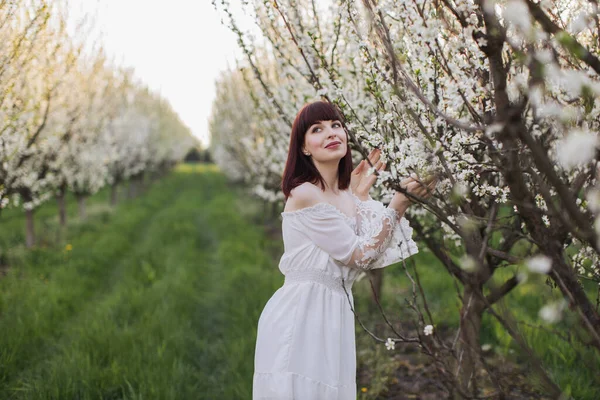 Bahar bahçesinde duran rüya gibi bakışlı sevimli bir kadın.