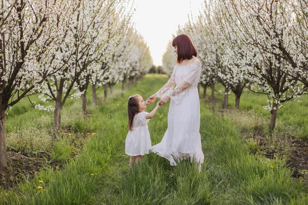 Sevgili anne kızıyla birlikte çiçek açan bahçede oynuyor. — Stok fotoğraf