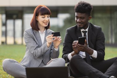 Açık havada banka kredi kartı ve akıllı telefonu olan iki ortak kültür ortağı.