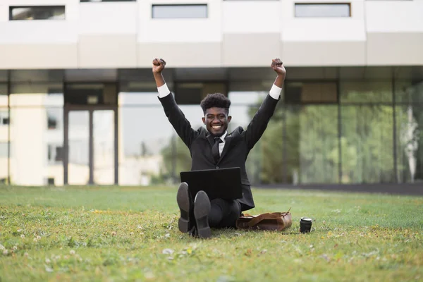 Beau jeune homme d'affaires africain de 30 ans avec les mains levées travaillant à l'extérieur — Photo