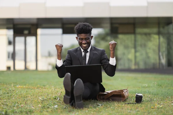 Beau jeune homme d'affaires africain de 30 ans avec les mains levées travaillant à l'extérieur — Photo