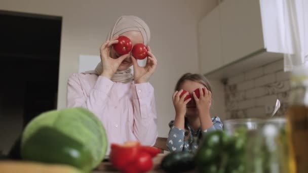 Arabian madre sentarse en la mesa de la cocina con poco lindo preescolar hija enseñar cocina ensalada — Vídeo de stock