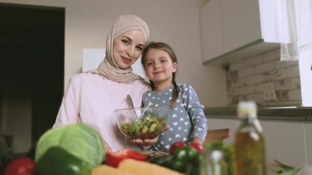 Fejlövés portré mosolygós arab muszlim nő fehér lánya főzés saláta együtt — Stock videók