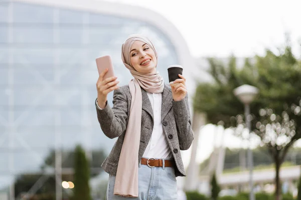 Gut gelaunte arabische Geschäftsfrau steht vor neuem, modernem Gebäude — Stockfoto