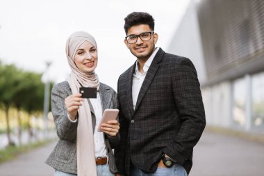Çevrimiçi olarak finans işlemlerini yürüten iki çok ırklı iş adamı.