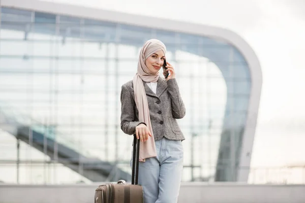 Mujer árabe de pie con la maleta cerca del aeropuerto —  Fotos de Stock