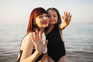 Mutlu bir aile. Genç güzel anne ve kızı sahilde eğleniyorlar..