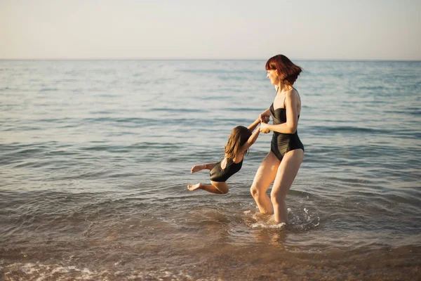 Madre e figlia a riposo in mare. La famiglia è sulla spiaggia di mare. — Foto Stock