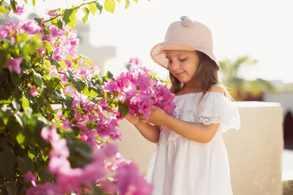 Menina encantadora está posando entre arbustos florescendo na primavera ao ar livre. — Fotografia de Stock