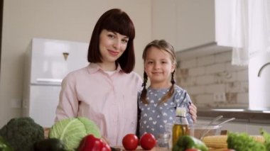 Mutfakta mutlu bir aile. Küçük anne ve kız birbirlerine sarılıp bakıyorlar.