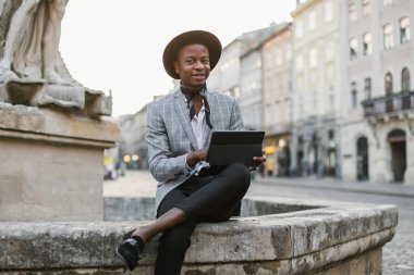 Caddede dijital tablet kullanan yakışıklı Afrikalı adam.
