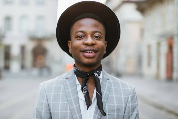 Afrikai férfi elegáns viselet és kalap pózol a város utcáján — Stock Fotó
