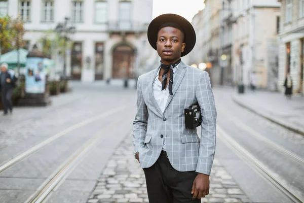 Hombre africano en traje elegante y sombrero caminando por la calle de la ciudad — Foto de Stock