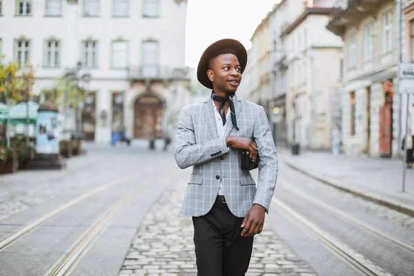 Homem africano em terno elegante e chapéu andando na rua da cidade — Fotografia de Stock