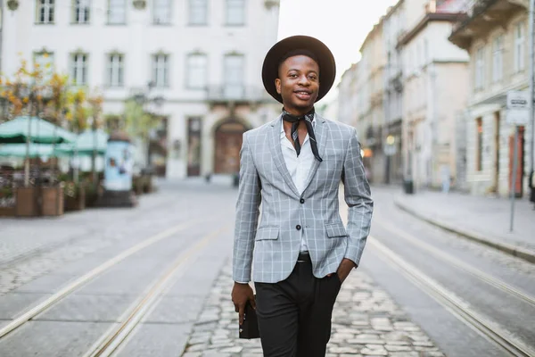 Afrikaanse man in stijlvol pak en hoed wandelen op straat — Stockfoto
