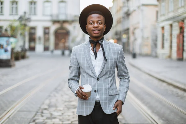 Homem africano elegante de pé na rua com xícara de café — Fotografia de Stock
