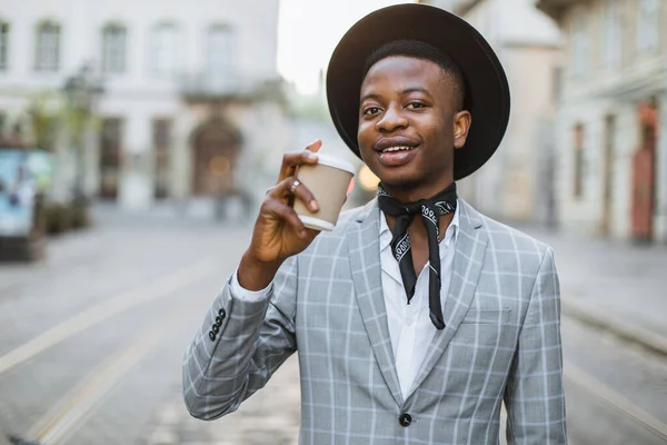 Afrikaanse man in stijlvol pak die koffie drinkt op straat — Stockfoto