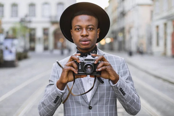 Homem africano usando câmera de fotos vintage enquanto caminha — Fotografia de Stock