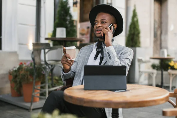 Homme africain utilisant tablette et mobile tout en étant assis au café — Photo