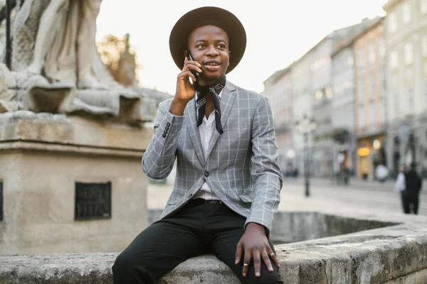 Afrikaanse man in stijlvolle kleding praten op mobiel buiten — Stockfoto