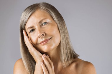 Stüdyoda doğal kırışıklıkları olan hoş beyaz bir bayan.