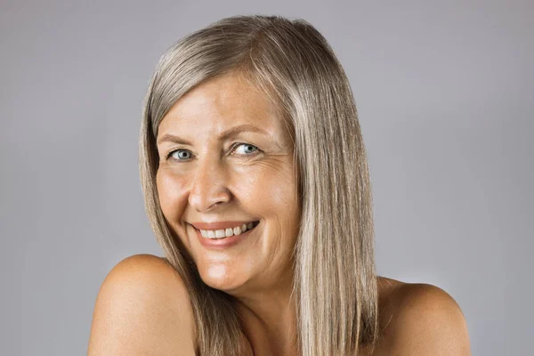 Aged woman with sincere smile posing in studio — Stock Photo, Image