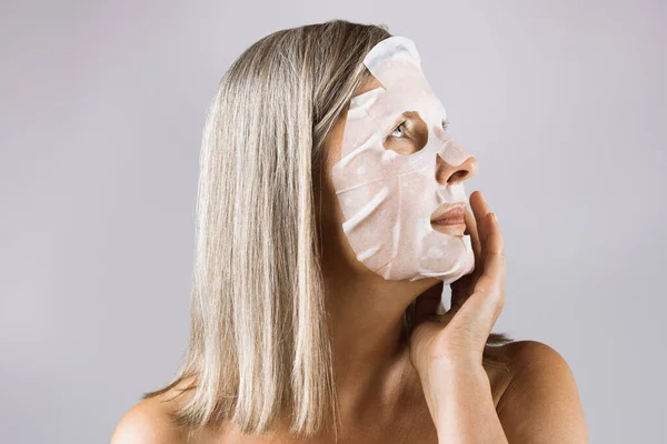 Öregedő kaukázusi nő szövet ruha arc maszk — Stock Fotó
