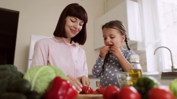 Kavkazský mladý maminka a roztomilý malé školačka dcera bavit příprava jídla — Stock video