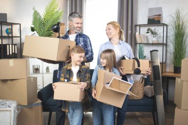 Yeni apartmanında kutuları olan mutlu beyaz bir aile.