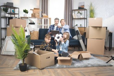 Çocuklar kanepede oturup dizüstü bilgisayar kullanırken oyun oynuyorlar.