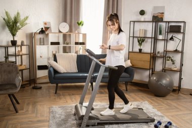 Vücudunu düzelt. Mükemmel durumda. Dayanıklılık artıyor. Kardiyo yapan genç bir kadının portresi.