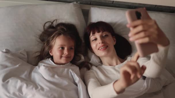 Szczęśliwy młody biały matka biorąc selfie z jej mało słodkie córka. — Wideo stockowe