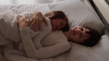Anne ve kızı yatakta döşeme.