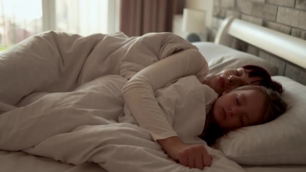 Bela jovem caucasiana mãe mulher dormindo com seu bebê bonito saudável menina no travesseiro na cama — Vídeo de Stock