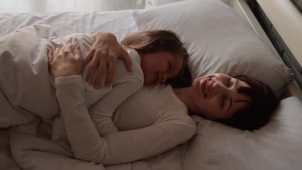 Mutter und Tochter liegen im Bett. — Stockvideo
