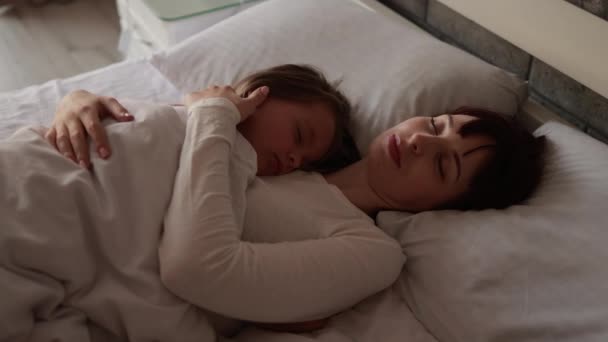 A nice girl and her mother enjoy sunny morning while sleeping together. — Video Stock