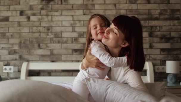 Jonge moeder spelen met haar baby meisje in de slaapkamer. — Stockvideo