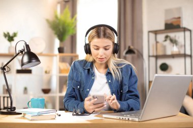 Güzel kız sıkı çalışmadan sonra müzik dinlemek için ara veriyor.
